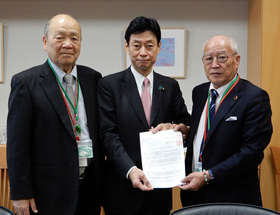 西村担当大臣（中央）に政策要請書を手渡す坂本三郎・県連委員長（右）と金田頼一・兵企連理事長（左）（4月2日・東京）