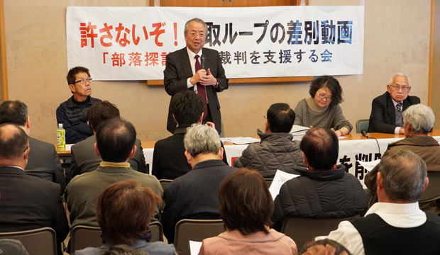 報告集会で主催者あいさつする片岡明幸・埼玉県連委員長（3月13日・さいたま市）